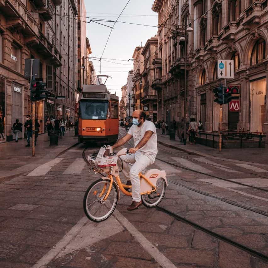 Hombre en bicicleta frente a un tranvía en Milán, ilustrando una noticia sobre la red ciclista Cambio planificada en Milán