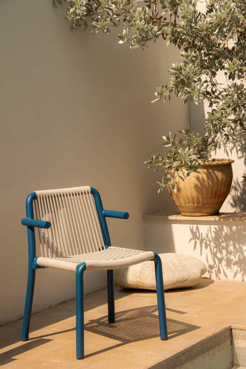 Fotografía de una silla azul y beige junto a la piscina