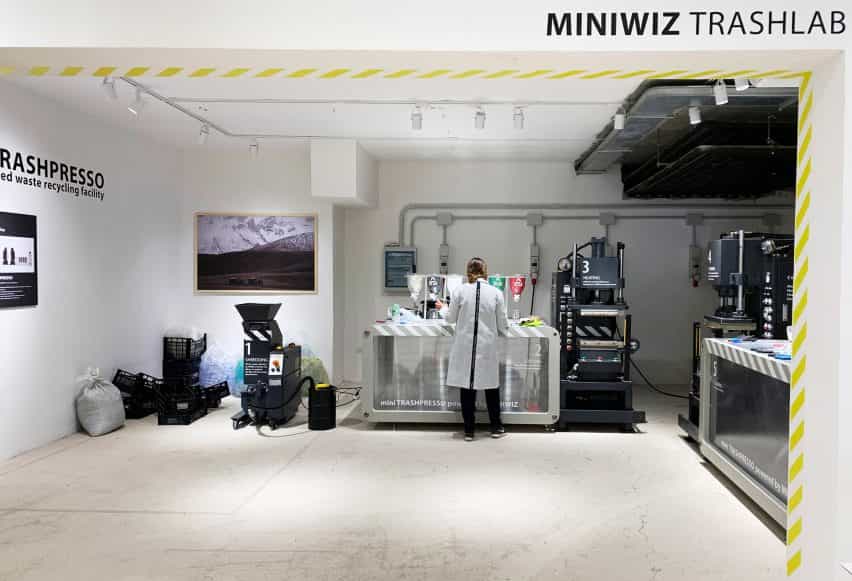 Persona con bata de laboratorio clasificando residuos plásticos en el espectáculo emergente Miniwiz Trashlab en Cerdeña