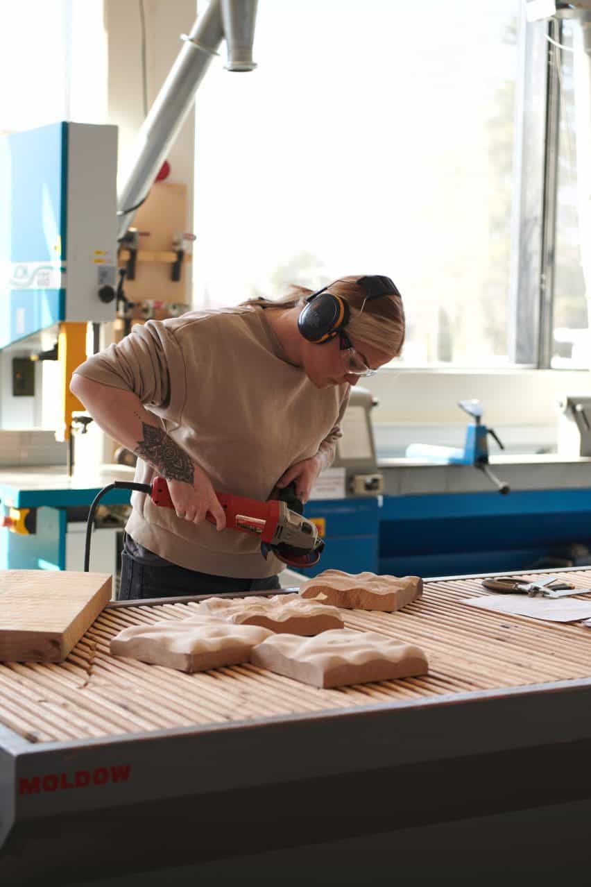 Diseñador trabajando en piezas de madera para la exposición Three