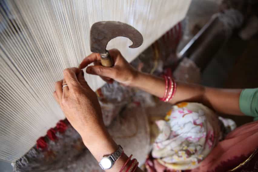 Deepak estar anudado a mano en la fábrica de las alfombras de Jaipur