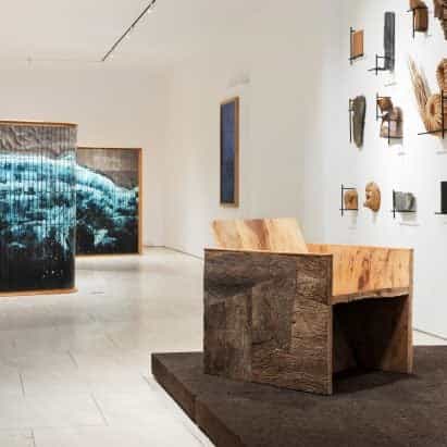Muebles forrados de corteza entre vitrinas de la obra de Noé Duchaufour-Lawrance en Nueva York