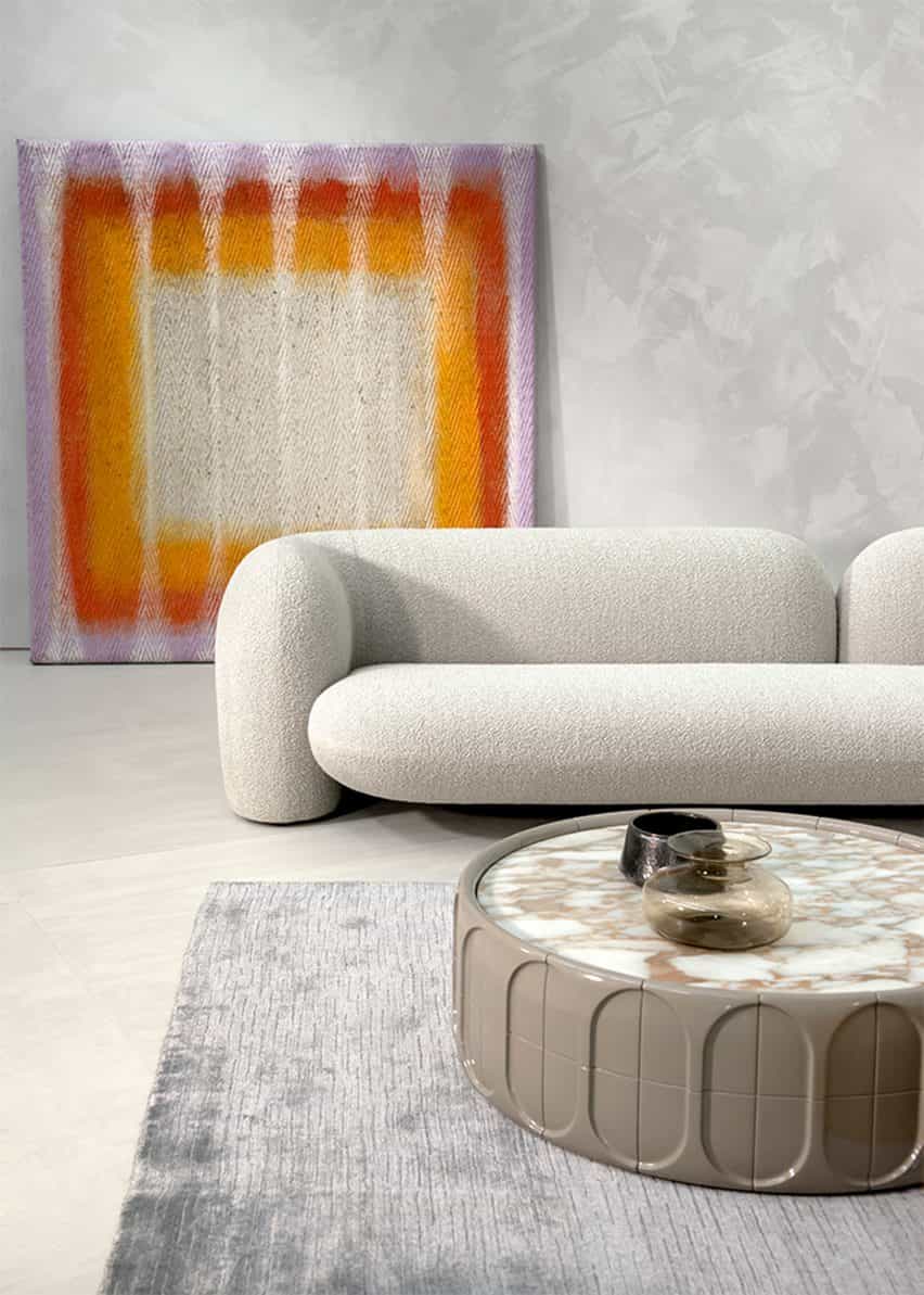 Imagen del sofá Gio en una habitación con una obra de arte arco iris detrás de él