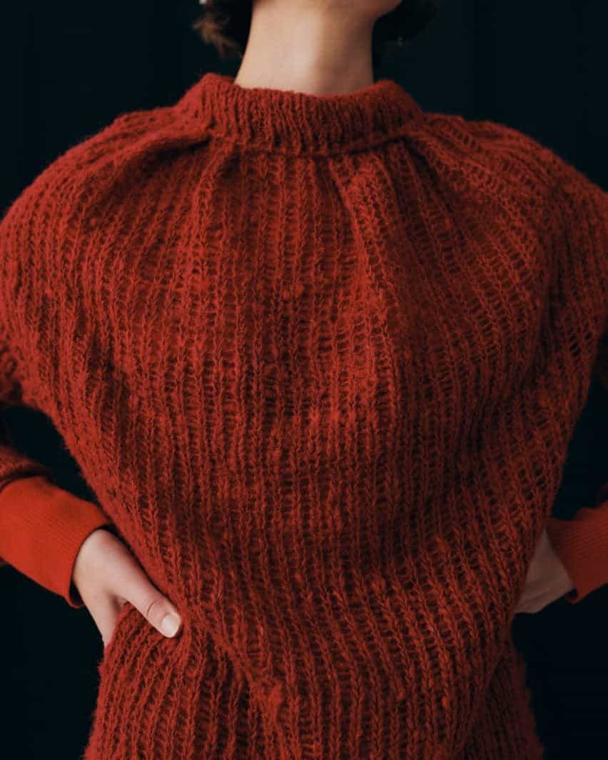 Foto del torso de una mujer con un suéter de punto rojo intenso