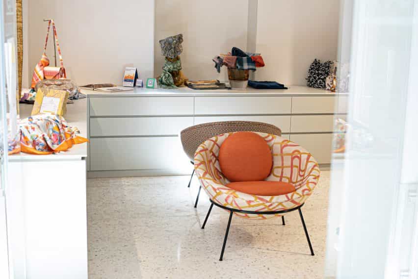 Sillas de tazón Orange Bardi's en un interior blanco con gabinetes circundantes y accesorios para el hogar