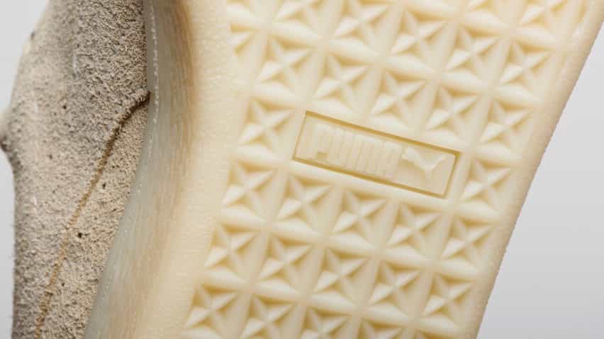 Foto de primer plano de la suela de goma de color beige de las zapatillas biodegradables Re-Suede de Puma, que muestra la pisada y el logotipo de Puma