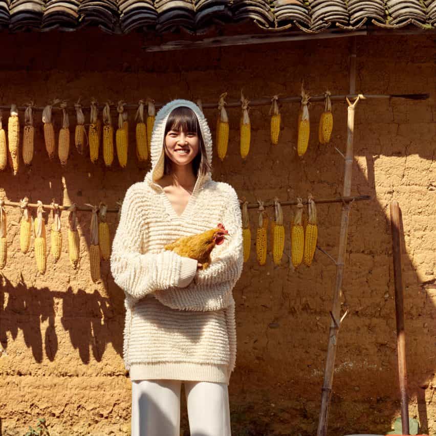 Mujer sosteniendo un pollo mientras usa un cárdigan blanco esponjoso de la marca china Icicle