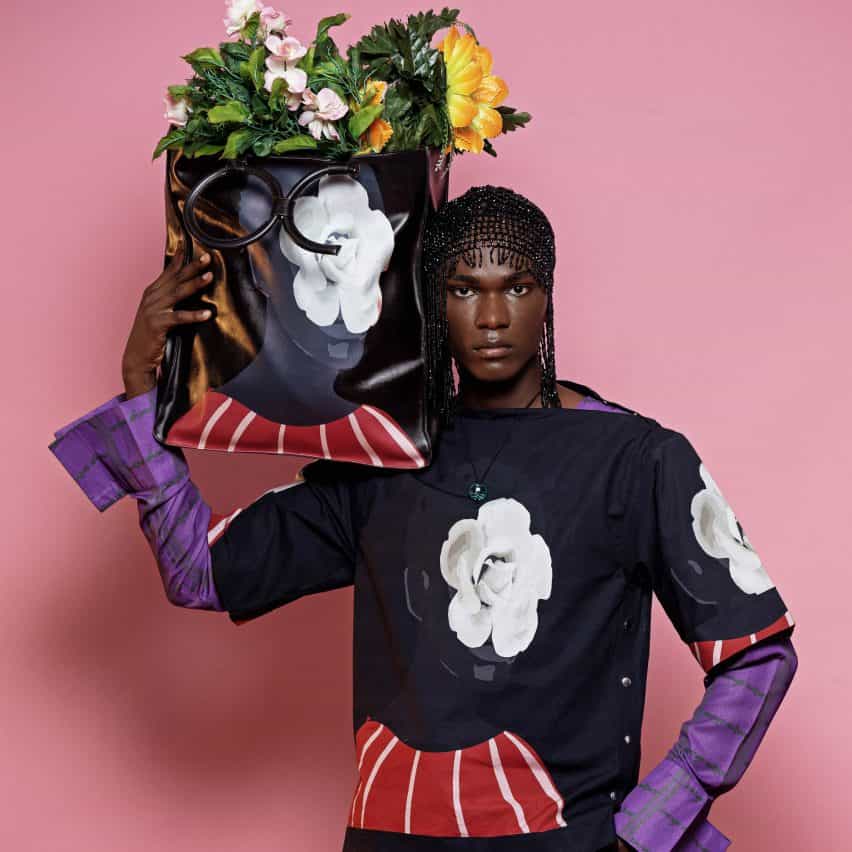 Modelo sosteniendo una bolsa de mano con flores del lookbook SS22 de Orange Culture, fotografiada por Jolaoso Wasiu Adebayo