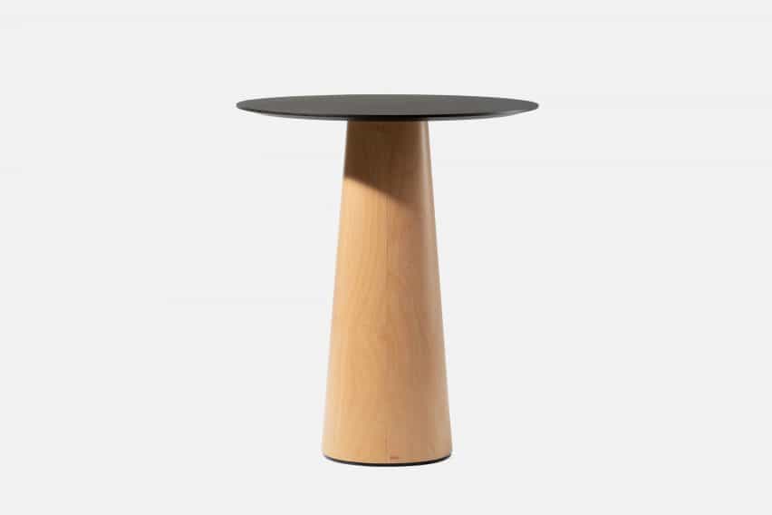 Pequeña mesa de madera contrachapada con un top negro