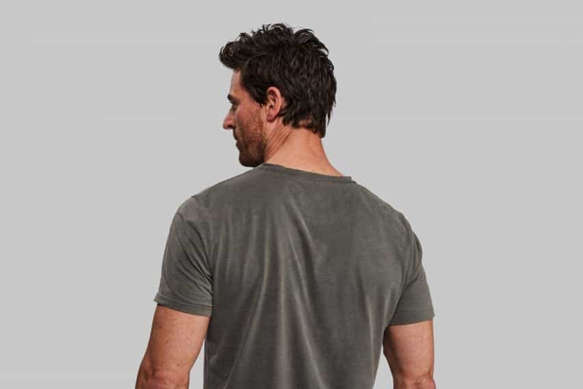 Vista trasera de una persona con camiseta negra de tinte de algas de Vollebak y Living Ink