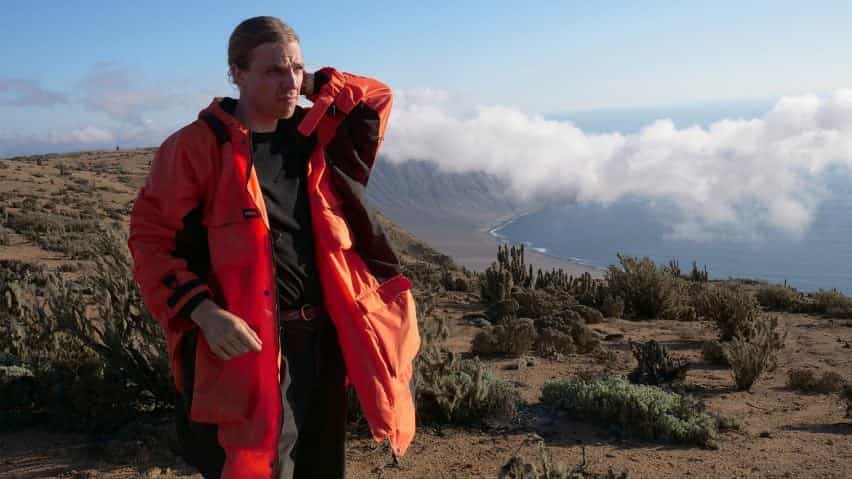 Pavel Hedström lleva la chaqueta antiniebla Fog-X que diseña en una meseta seca con una nube baja colgando en el fondo