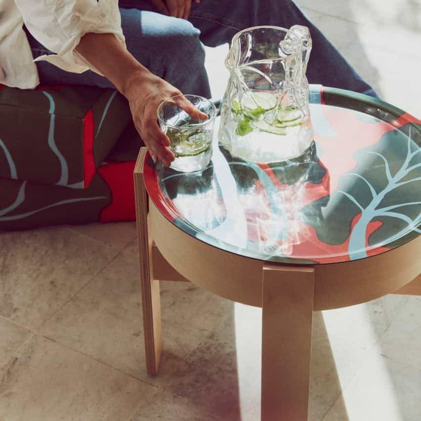 Mesa circular de madera con un tablero rojo con un estampado de hojas