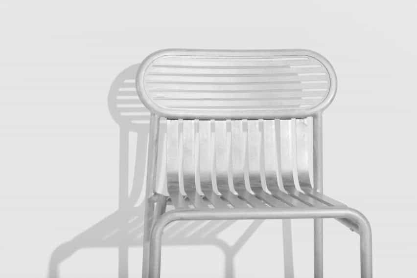 Detalle de silla metálica brillante en habitación blanca