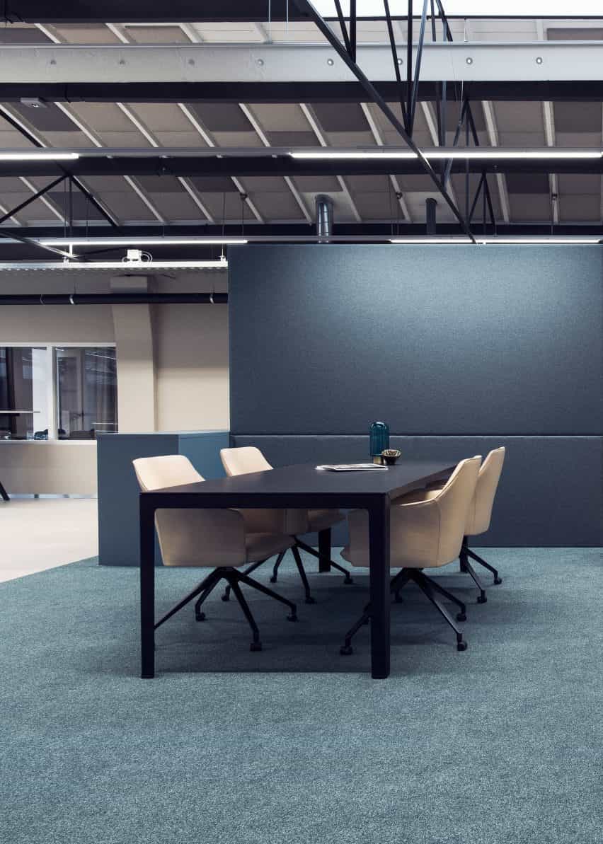 Cuatro sillones LXR671 en color beige rodeando un escritorio negro situado en un entorno de oficina