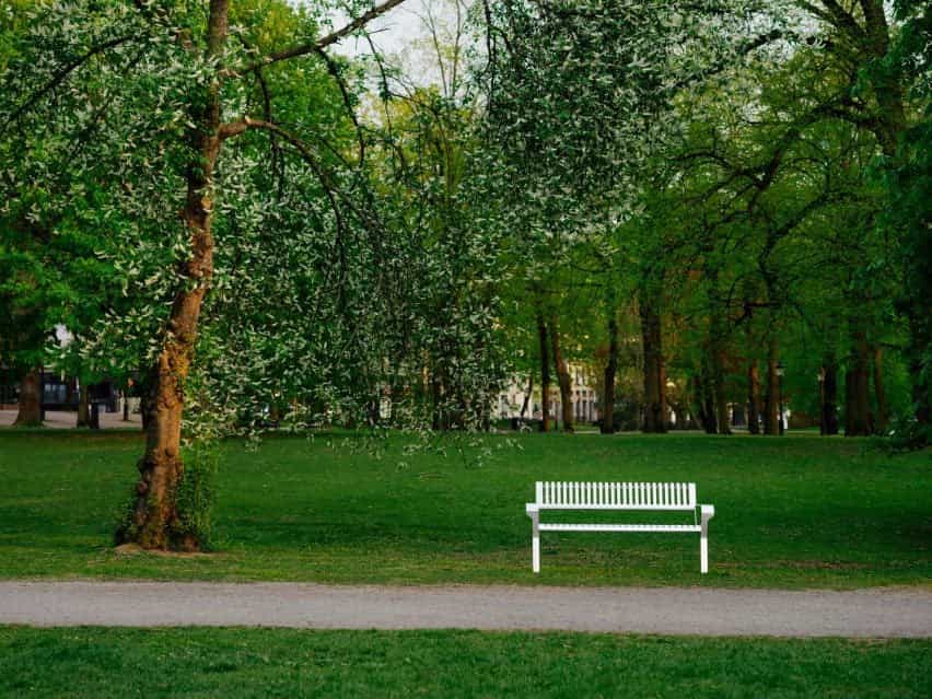 Foto del banco de acero Tellus en un exuberante parque público verde