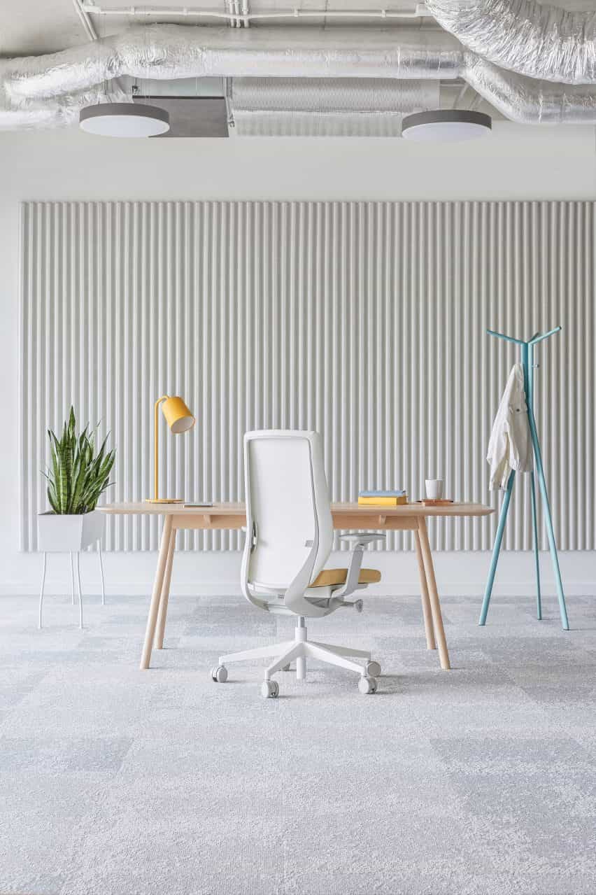 Un interior de oficina gris con una silla de oficina blanca